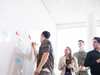 Vier Personen die gemeinsam eine Lösung an einem Whiteboard finden